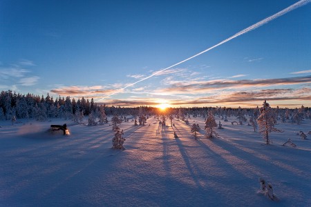 Moottorikelkkailua auringonnoussussa.