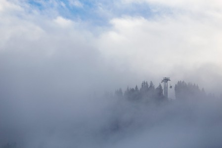 Schattbergin gondoli nostaa Saalbachin kylästä pilven läpi aurinkoiselle yläasemalle.