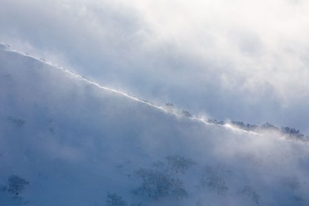 Tuuli pöllyttelee lumia Kiroron lähistöllä nousevan Mt. Yoichin harjanteelta. Tuulella laskijan kannattaa pöllytellä lumia alempana metsän suojassa.