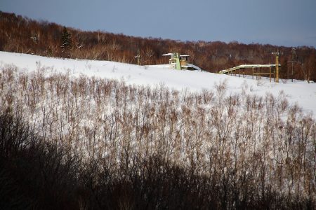 Iwanai Resortin maisemassa on vielä aikoinaan vuorella toimineen hiihtokeskuksen rapistuneet hissit ja rakennukset.